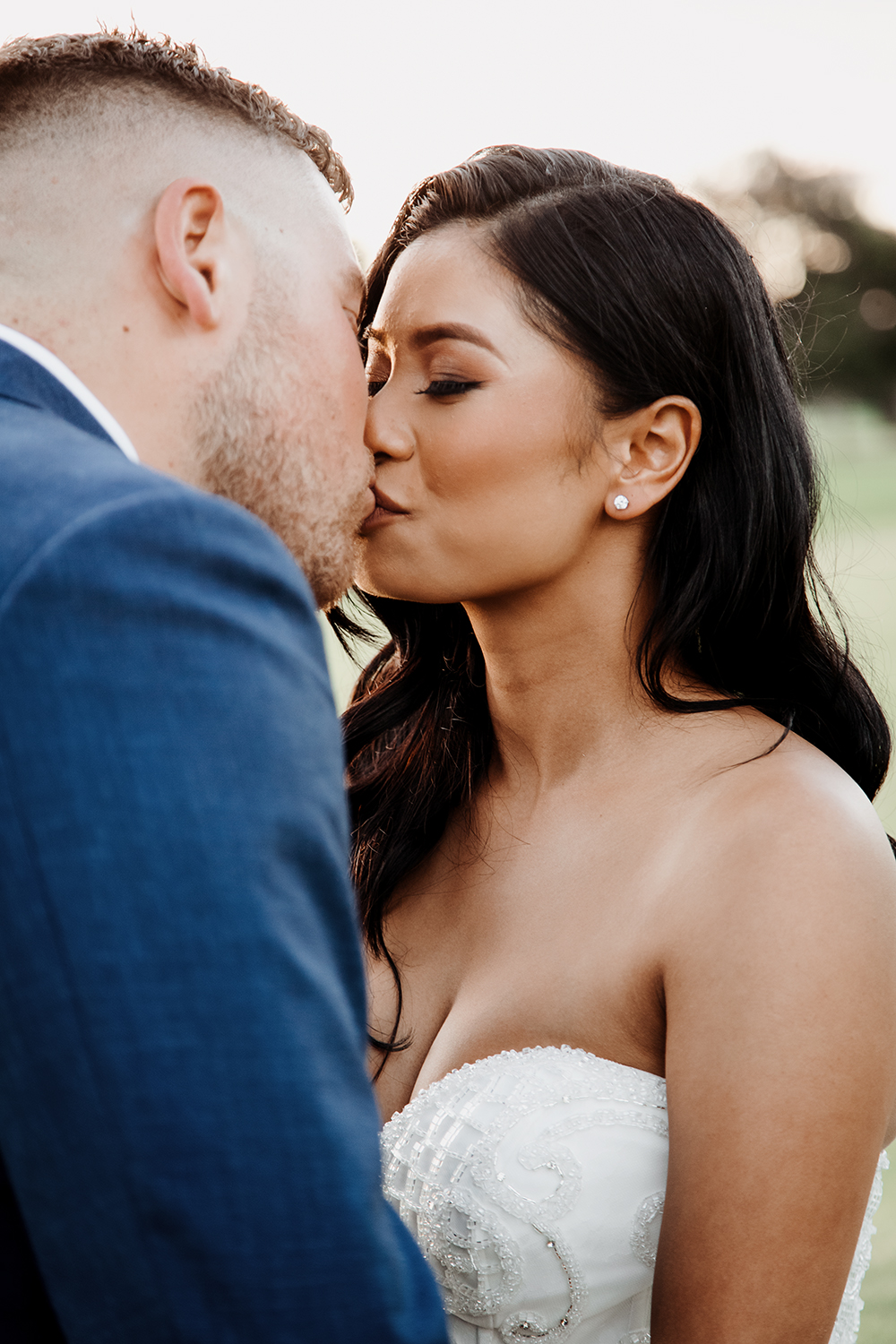 Emotional and natural portrait of the first kiss after the wedding ceremony. A close-up, candid shot of the bride and groom kissing, capturing genuine love and affection in soft natural light