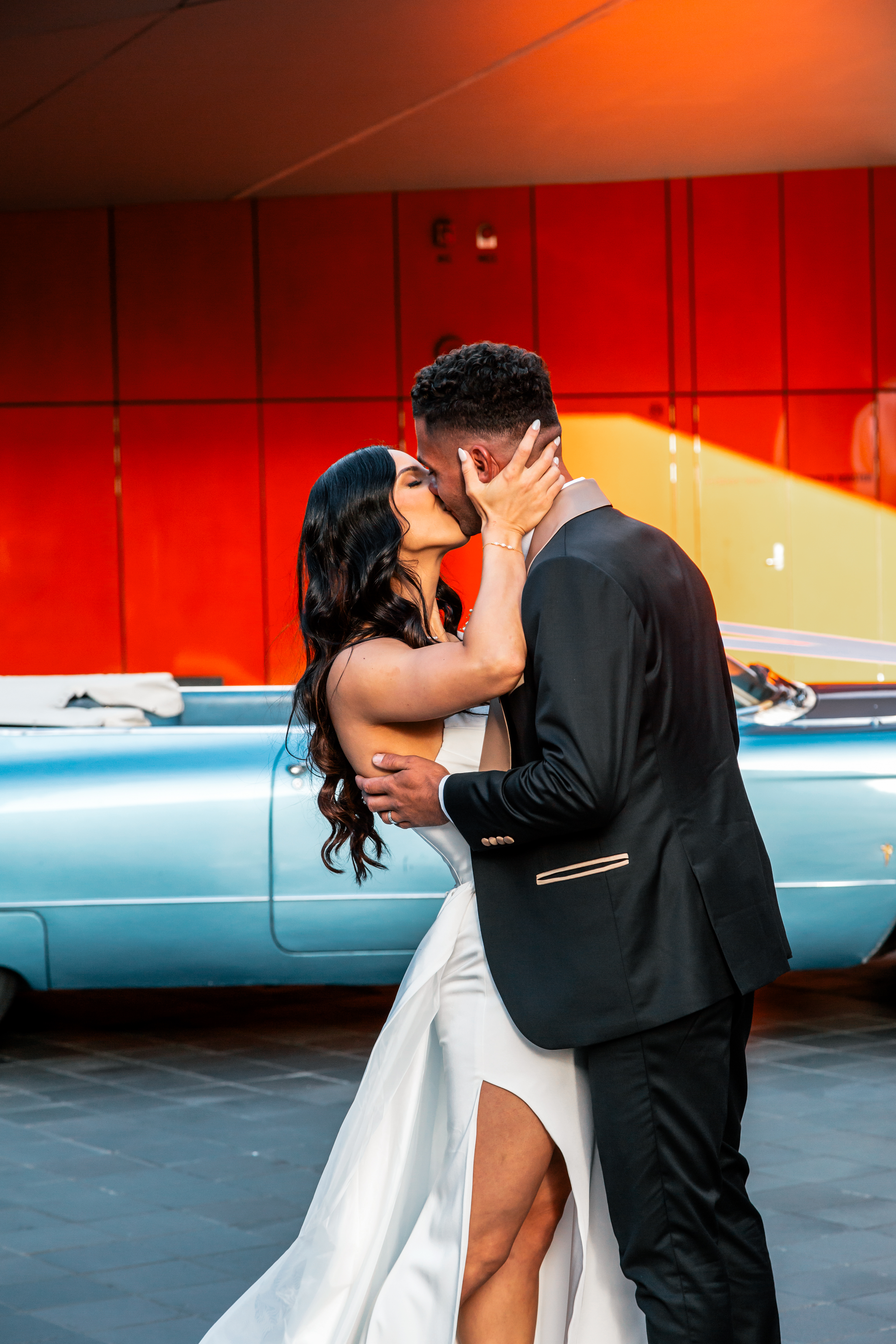 Bride and Groom Kissing, Bride in elegant white gown with thigh split and groom in black tuxedo, modern wedding photography Melbourne, relaxed couple portrait Yarra Valley and Mornington Peninsula